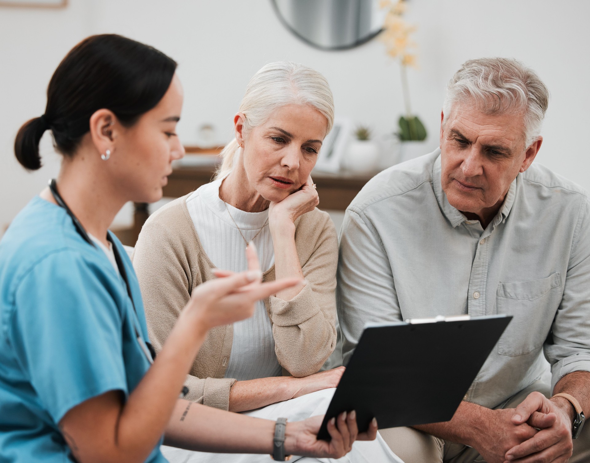 Senior couple, nurse and retirement document questions for hospital and health paperwork. Asian woman question, conversation and consulting survey in a wellness clinic with data and policy report